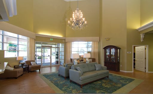 A spacious lobby area featuring elegant sofas, a chandelier, and tasteful decor.