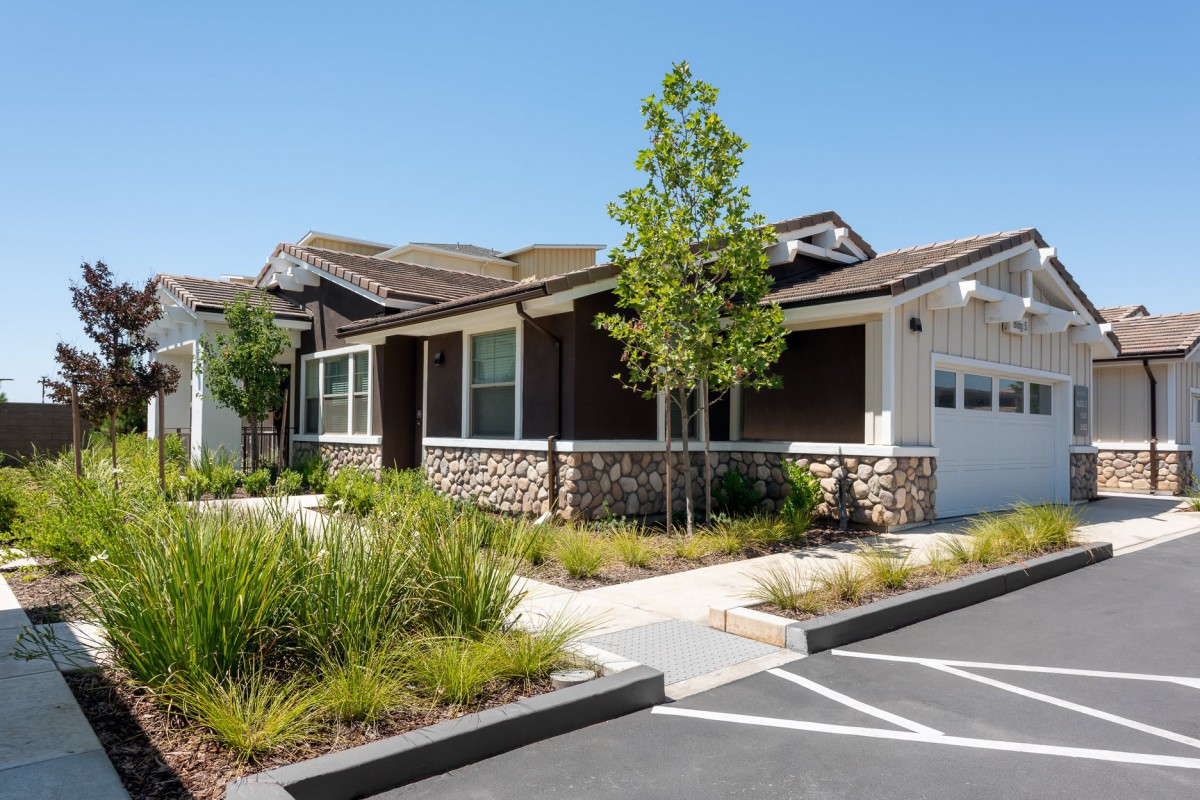 A suburban residential house with well-maintained landscaping and a driveway.