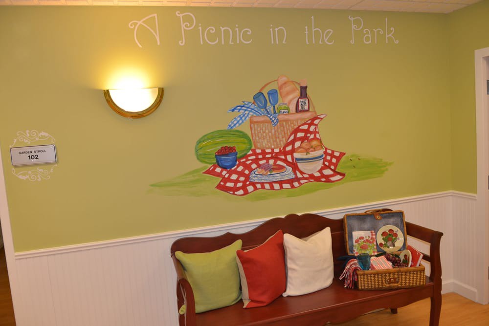 A cozy interior featuring a picnic-themed mural with a bench adorned with colorful pillows.