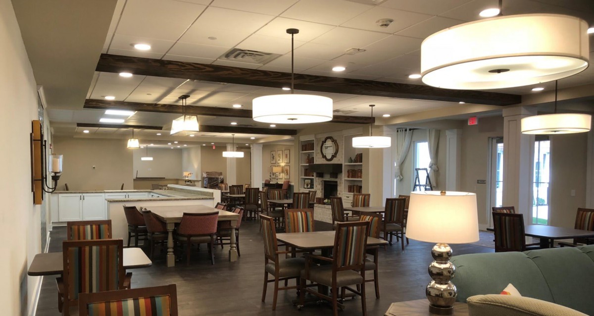 A cozy dining area with tables, chairs, and warm lighting.