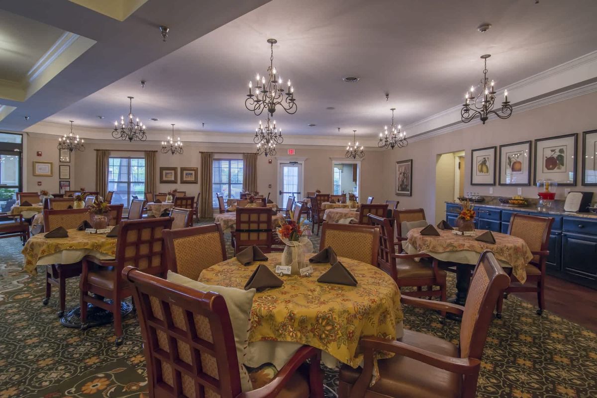 An elegant dining room with chandeliers and neatly arranged tables.
