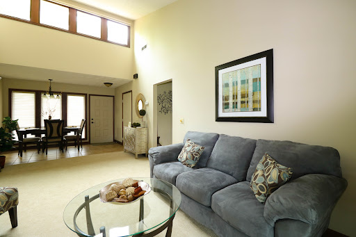 A modern living room featuring a cozy gray sofa, a stylish coffee table, and artwork on the walls, illuminated by natural light.