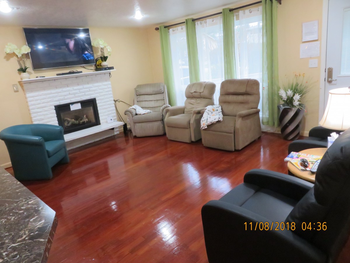 A cozy living room with comfortable chairs, a fireplace, and a television.