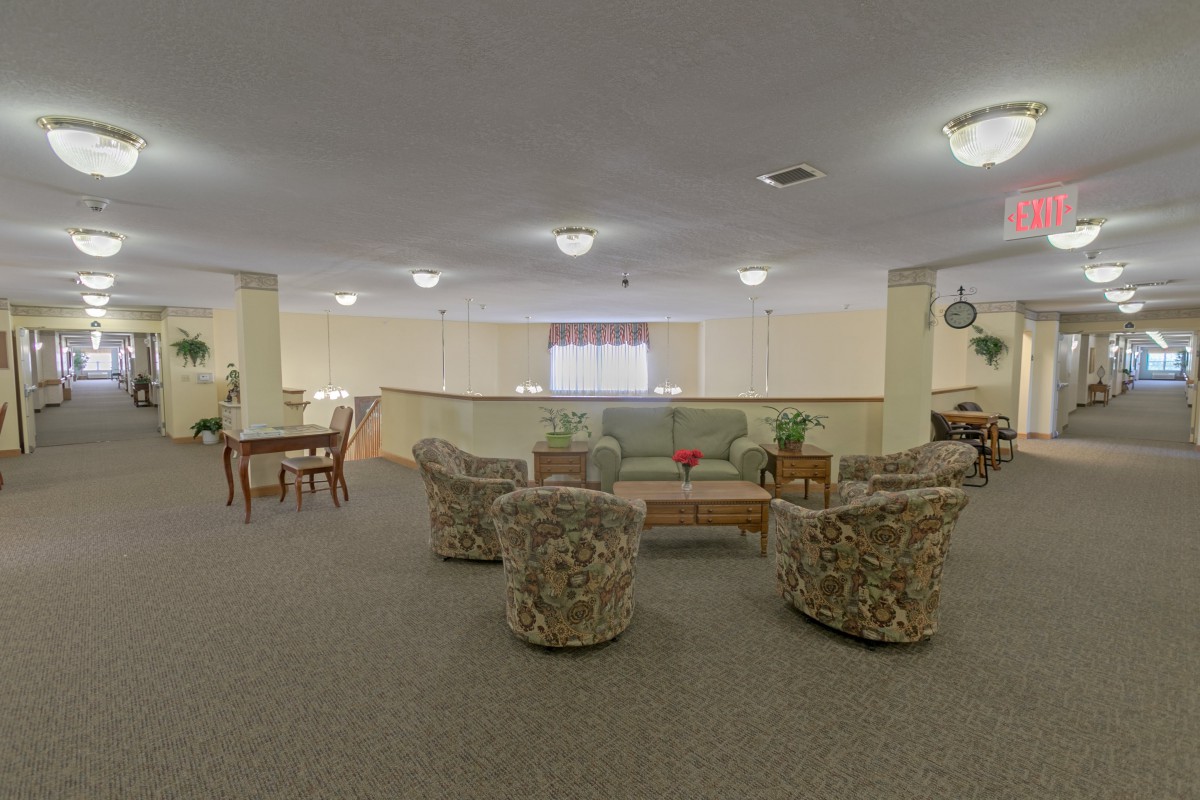 Spacious living room with armchairs arranged around a coffee table.