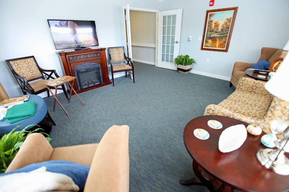A cozy living room featuring a fireplace, television, and comfortable seating.