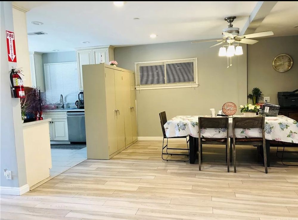 A cozy kitchen and dining area featuring a table with chairs, a ceiling fan, and a light fixture.