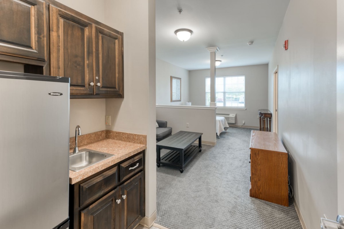A small apartment interior featuring a kitchenette and a cozy living area.