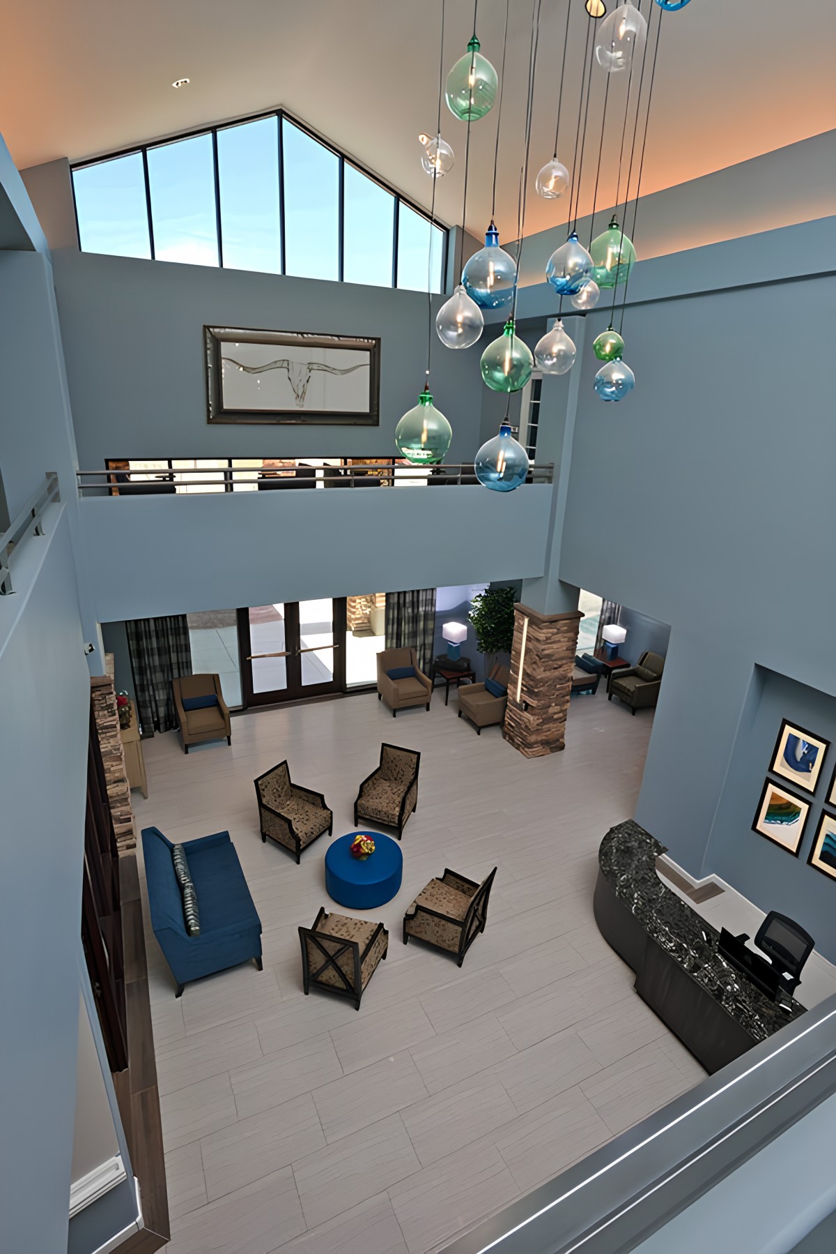 A spacious and modern lobby with a high ceiling, featuring stylish furniture and unique lighting fixtures.
