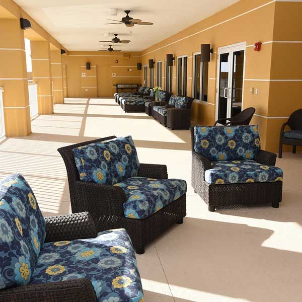 A spacious outdoor patio with comfortable seating and vibrant cushions on a sunny day.