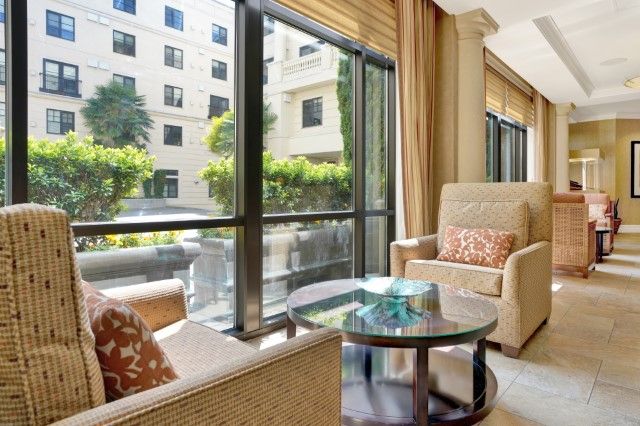 A modern living room featuring comfortable seating with large windows providing ample natural light.