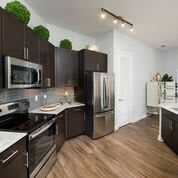 A modern kitchen with stainless steel appliances and dark cabinets.