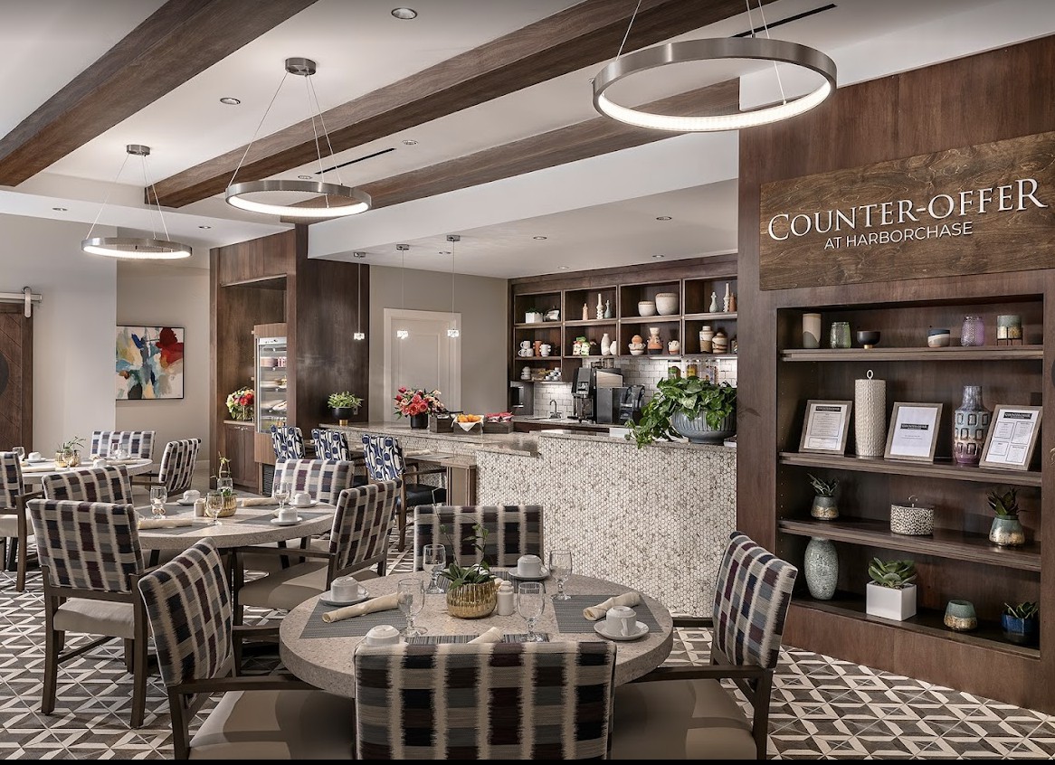 A modern restaurant interior with elegant dining tables and ambient lighting.