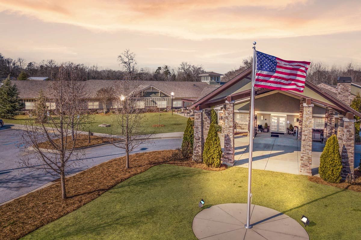 A scenic view of a building with an American flag flying at sunset.