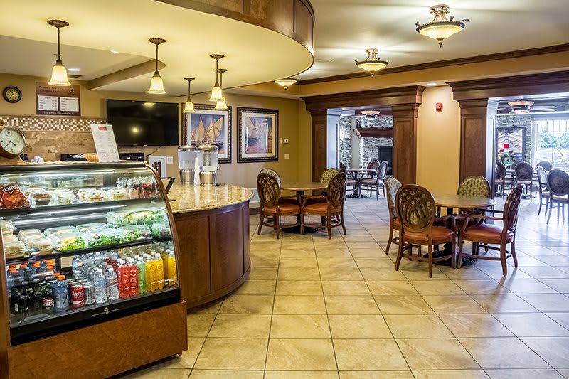 A cozy cafe interior with a seating area, beverage display, and modern lighting.