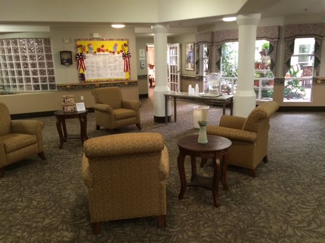 A cozy lobby area with armchairs and tables arranged in a welcoming setting.