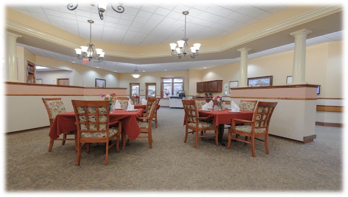 A spacious and elegantly decorated dining room with neatly arranged tables and chairs under chandeliers.