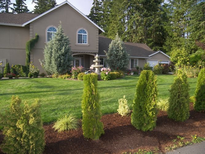 A beautiful house surrounded by a well-maintained garden with lush greenery.