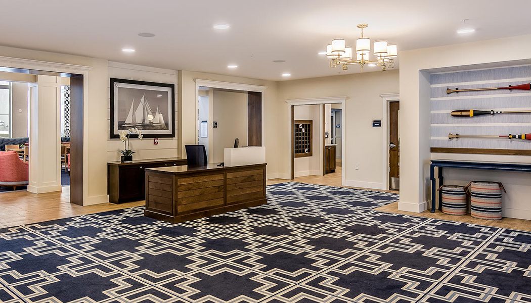 A modern office reception area with a stylish rug and artwork on the wall.