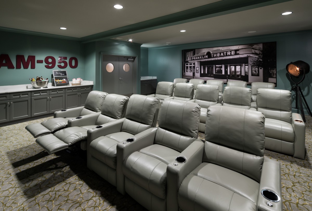 A cozy home theater with comfortable recliner seating and a vintage cinema theme.
