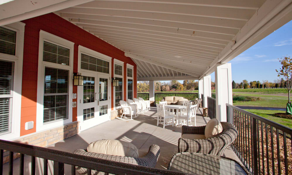 A spacious covered porch with comfortable outdoor seating and a view of the surrounding landscape.