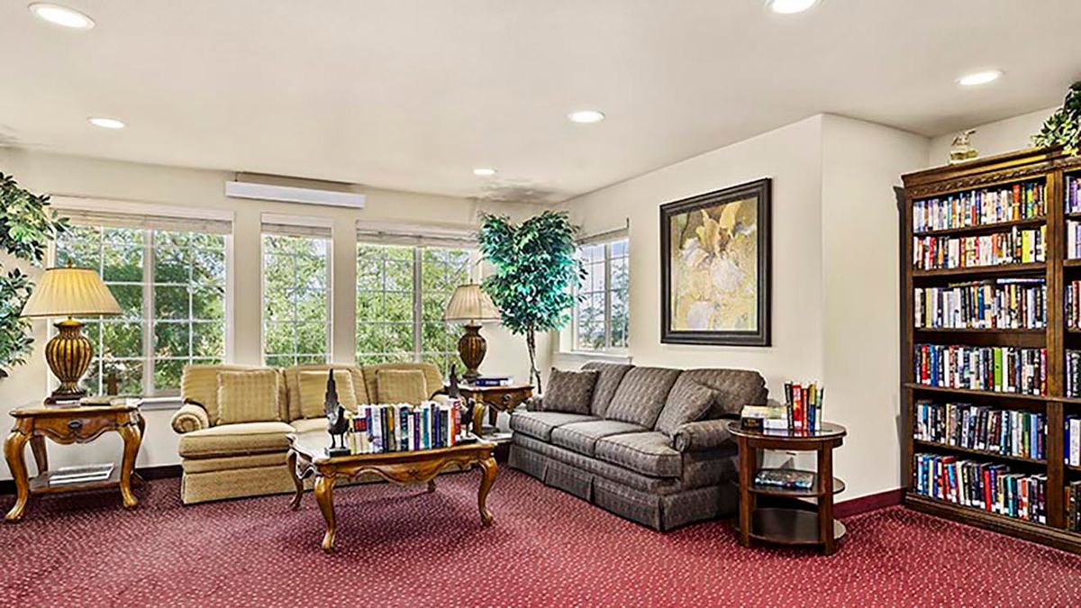 A cozy living room with comfortable seating, a coffee table, and decorative elements like artwork and plants.