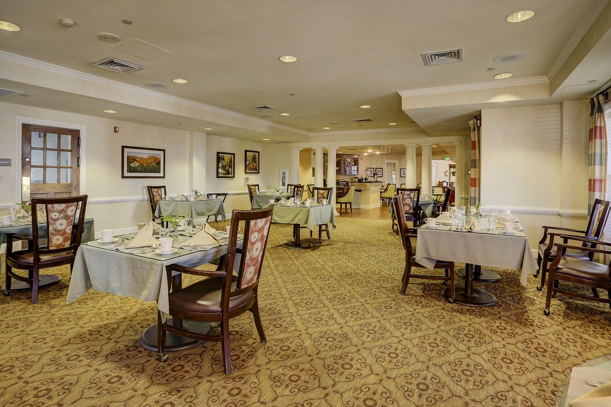 A spacious and elegantly decorated dining area with neatly arranged tables and chairs.
