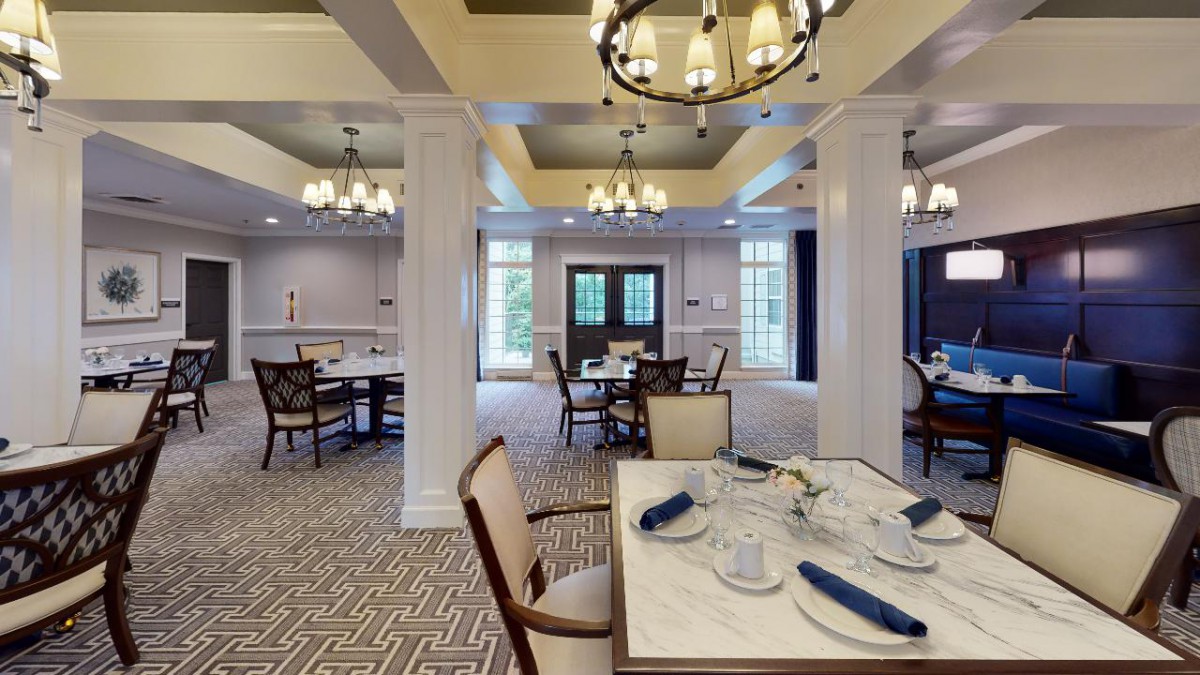 An elegant dining area with chandeliers, neatly arranged tables, and sophisticated dcor.