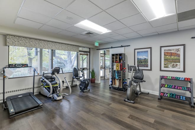 A well-equipped gym with exercise machines including treadmills and stationary bikes.