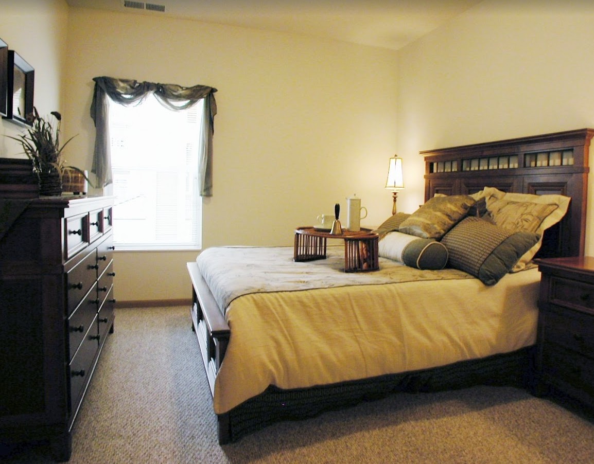 A cozy bedroom with a neatly made bed, soft lighting, and elegant decor.