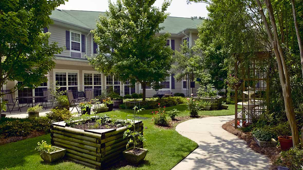A well-maintained garden with a winding pathway in front of a residential building.
