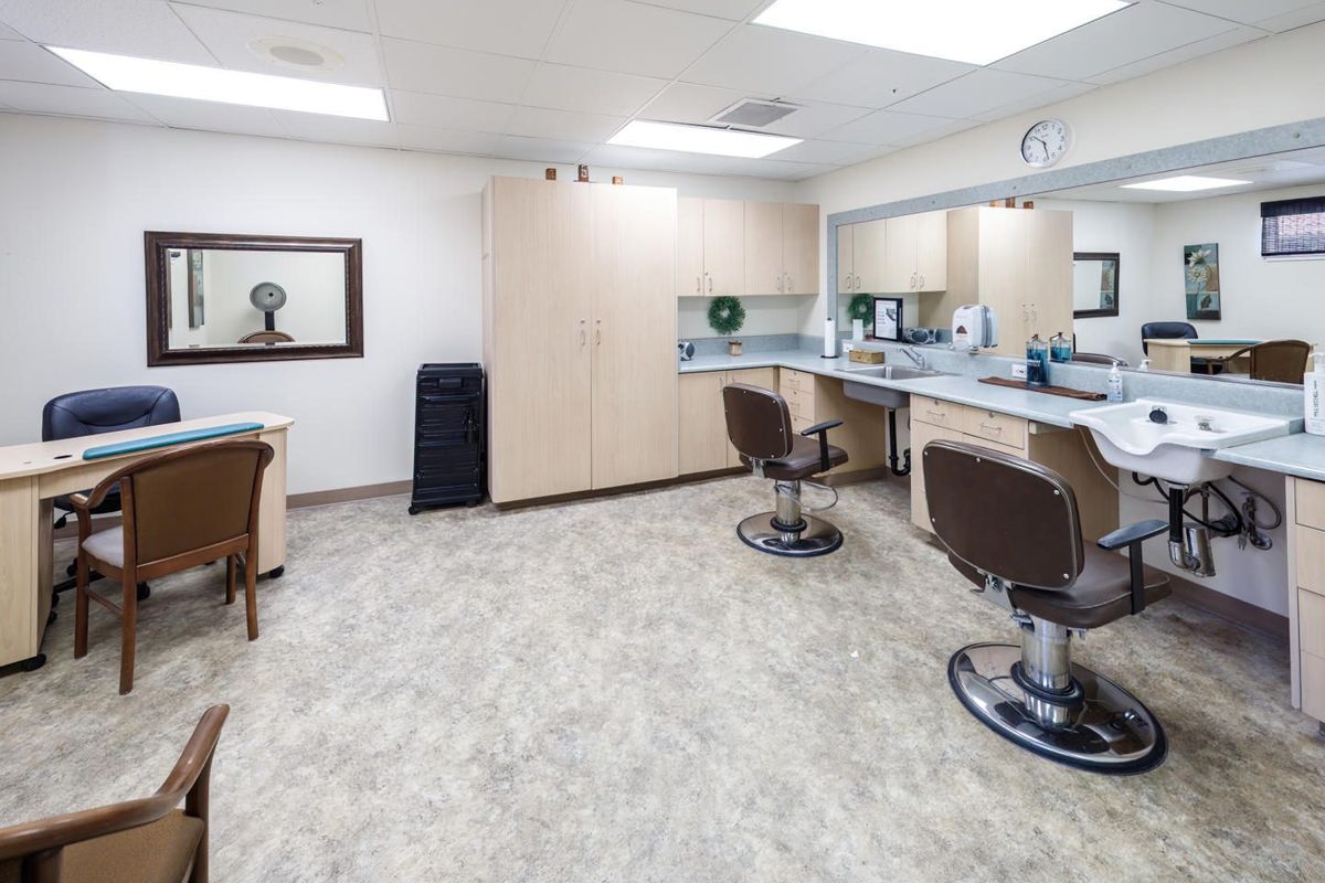 A well-lit barbershop interior with styling chairs and mirrors.