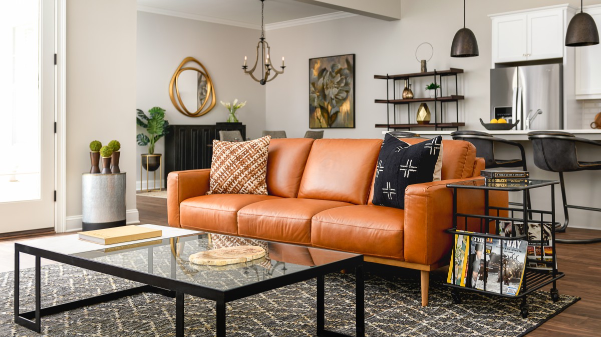 A stylish living room featuring a modern orange sofa and chic decor.