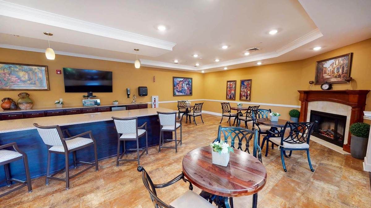 A cozy cafe space with tables, chairs, and a television.
