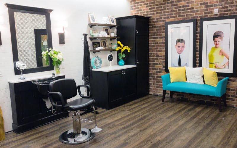 A well-decorated salon interior with a styling chair, mirror, and vibrant accents.