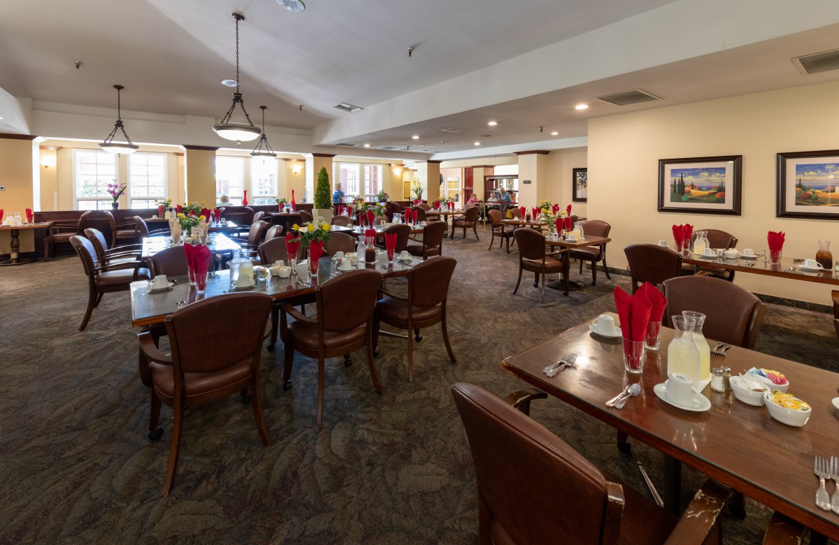 A spacious and elegantly decorated dining room with neatly set tables and comfortable chairs.