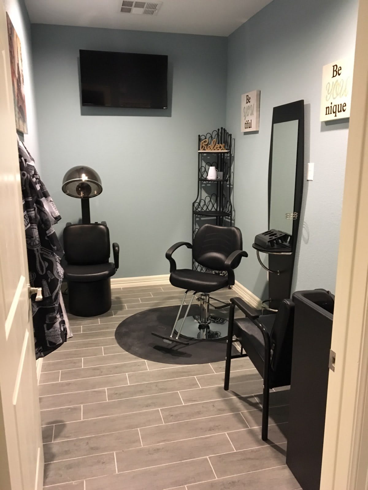 A cozy hair salon setup with a stylist chair, mirror, and hair dryer.
