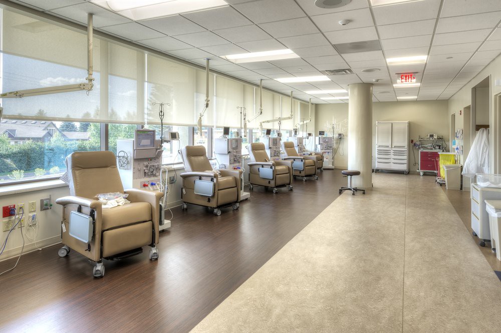 An empty medical treatment area with several reclining chairs and equipment.