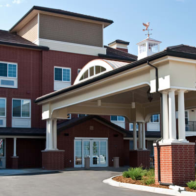 A building with a large covered entrance and multiple windows.