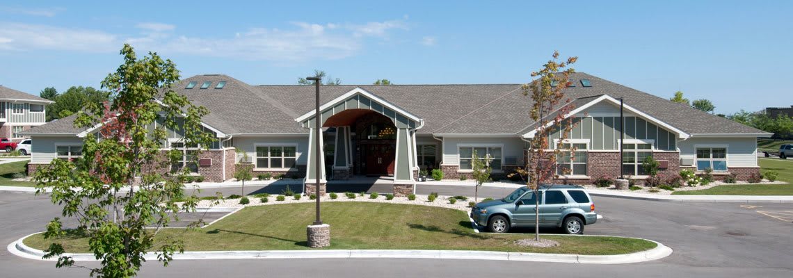 A single-story house with a front lawn and a parked car.