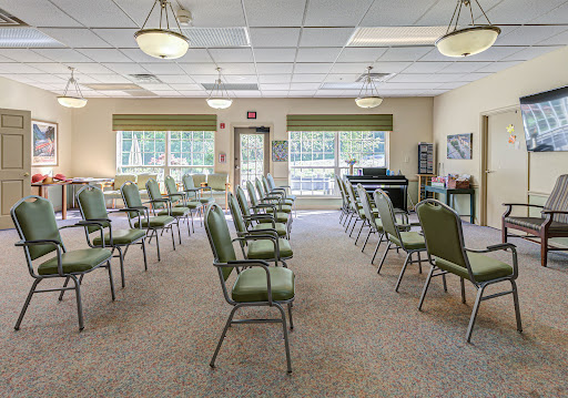 A spacious waiting room featuring rows of green chairs, ideal for gatherings or meetings.