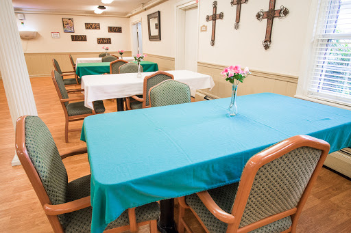 A serene dining area featuring neatly arranged tables with teal tablecloths and decorations.