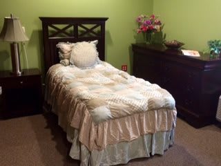 A cozy bedroom with a single bed and green walls.