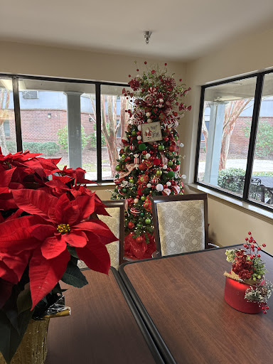A beautifully decorated Christmas corner with a tree and vibrant poinsettias.