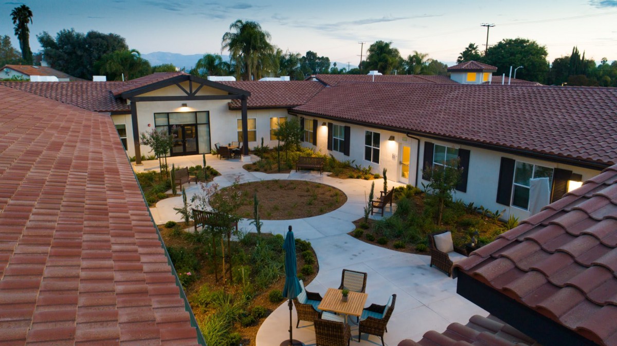 A residential courtyard with outdoor seating and garden in the evening.