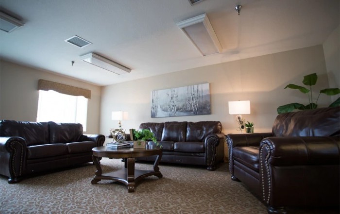 A cozy living room with leather sofas, a wooden coffee table, and soft lighting.