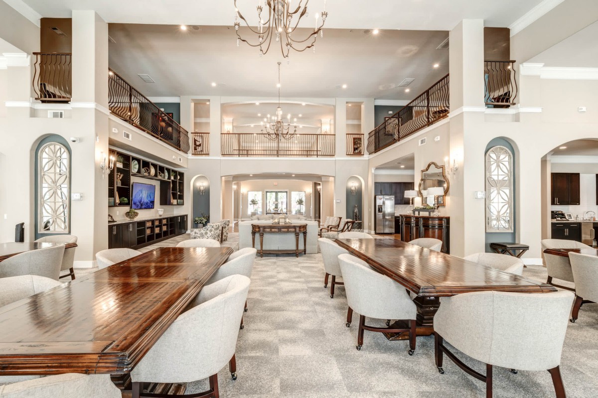 A luxurious and elegant dining room with spacious seating and a grand chandelier.