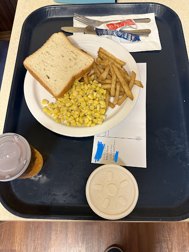 A simple lunch featuring corn, fries, a slice of bread, and a drink.