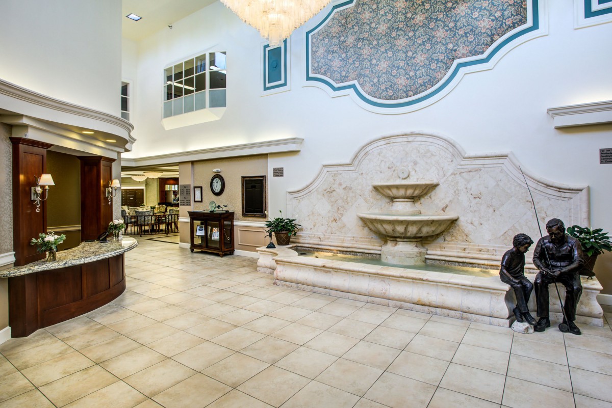 A spacious lobby with a decorative fountain and tiled flooring.