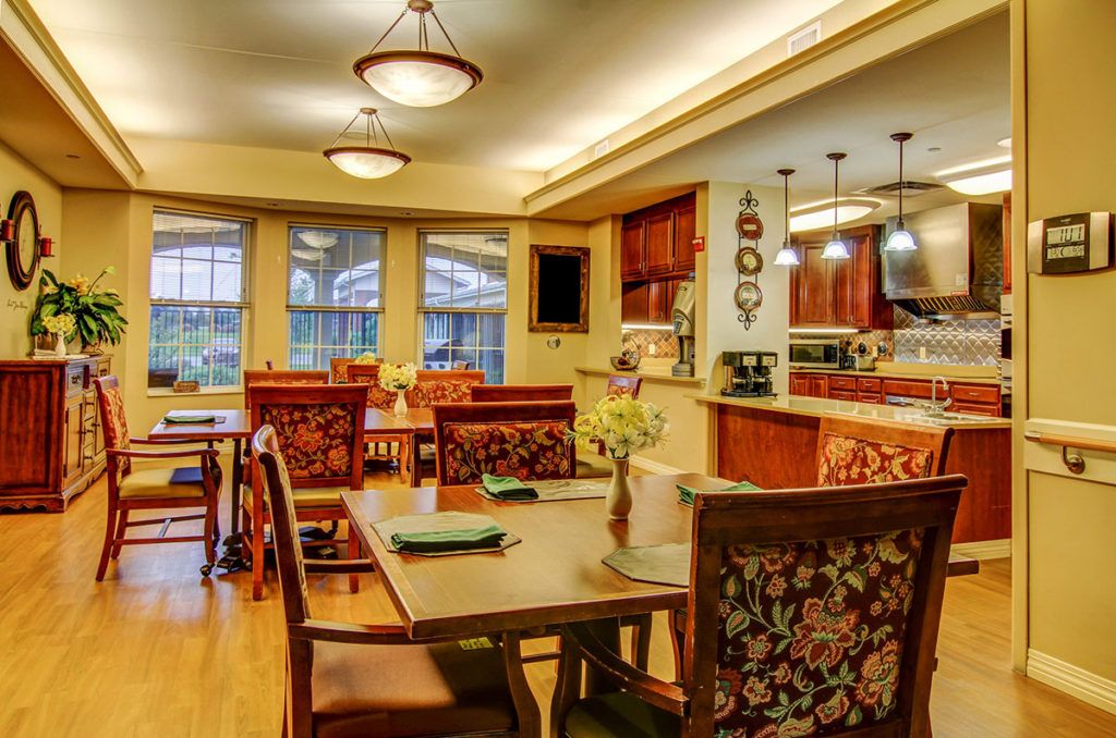 A cozy dining area with tables and chairs, warmly lit by ceiling lights.