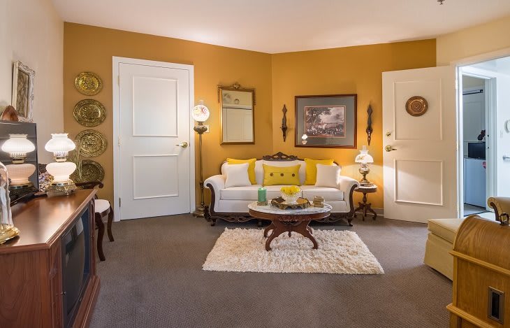 A cozy living room with a yellow-themed decor and vintage furnishings.
